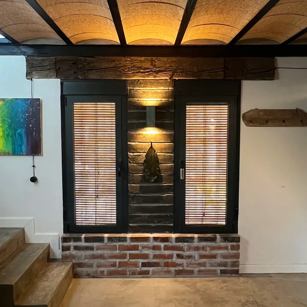 Entrada con ventanas de madera, techo abovedado y ladrillo visto